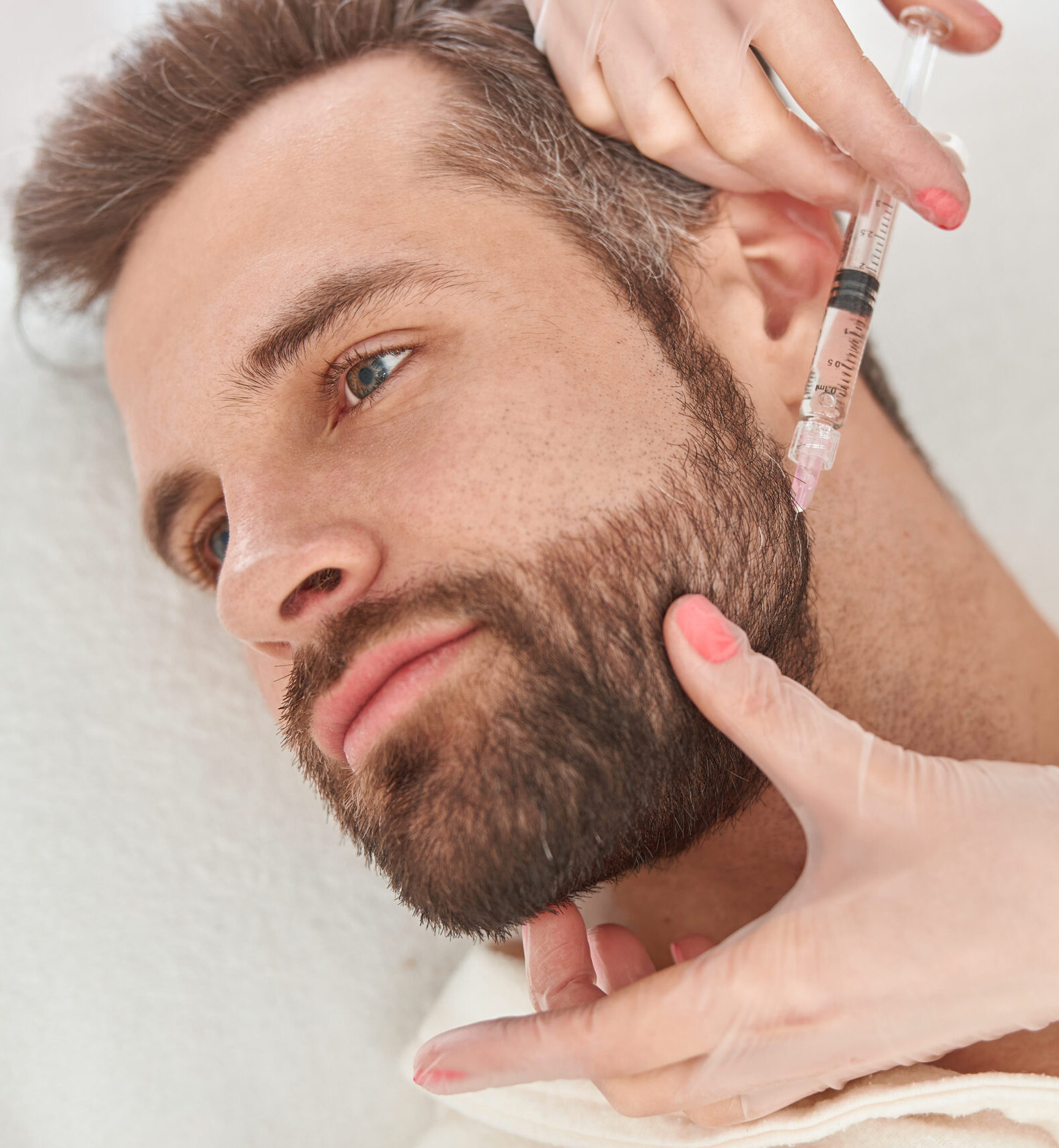 Close up makes mesotherapy injections to beard man. Treatment of male by a beautician for hair growth.