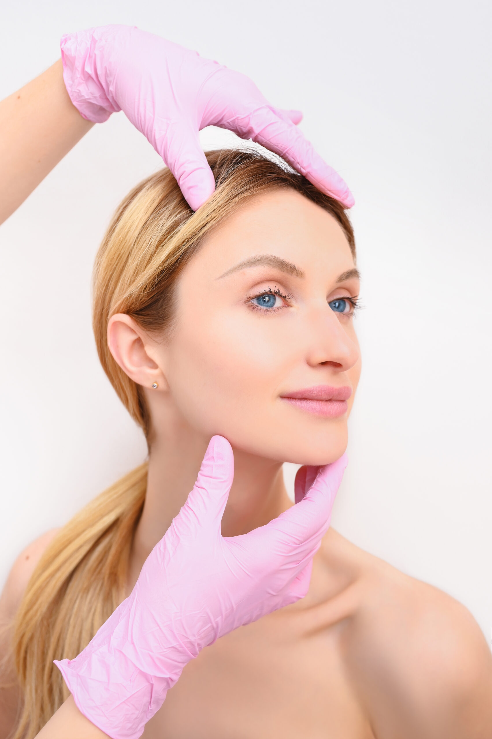 closeup-beautician-hands-gloves-touching-young-woman-s-face-plastic-surgery-concept-facial-beauty-portrait-beautiful-blonde-female-with-perfect-makeup-soft-smooth-skin