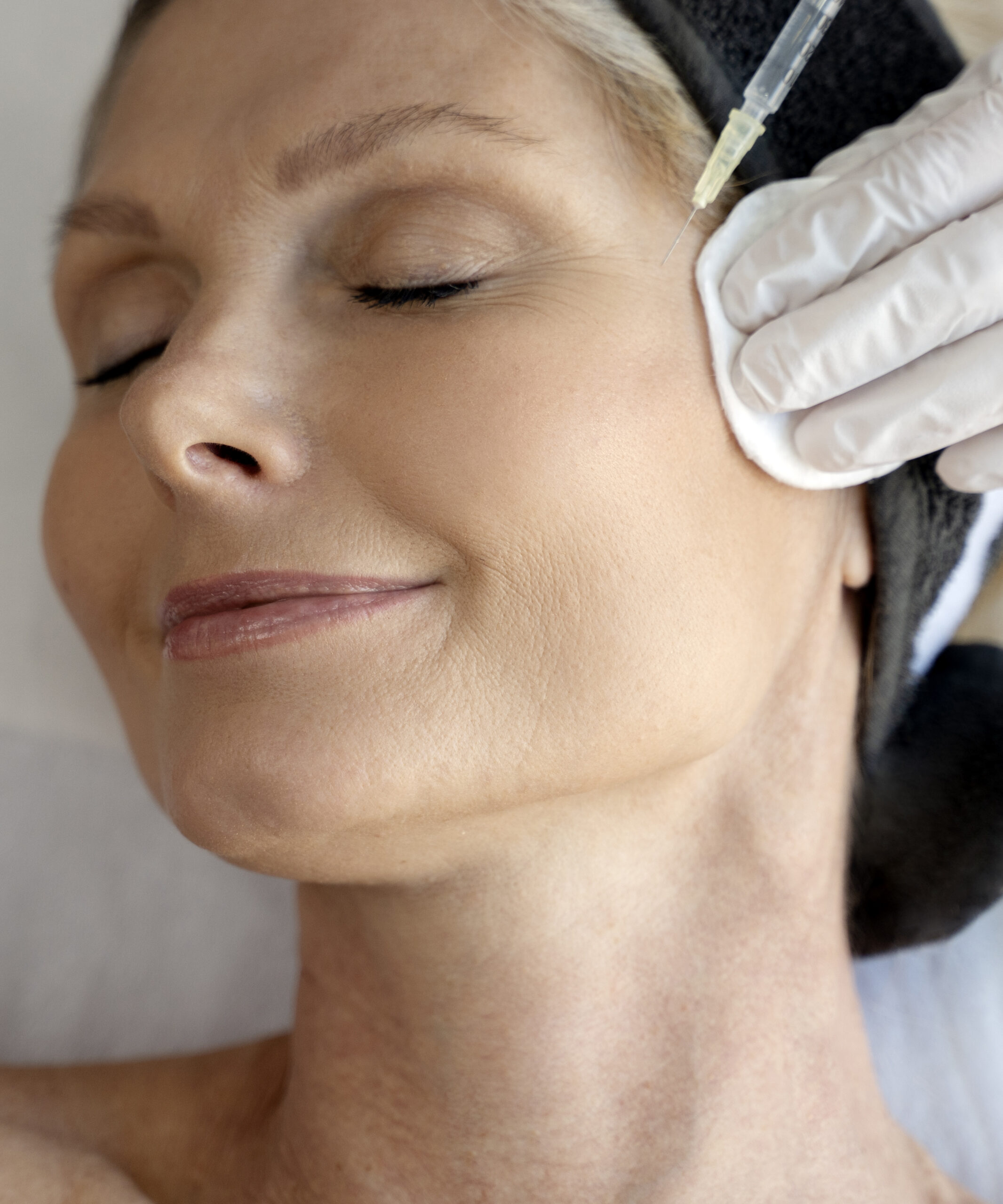 Senior woman relaxing during facial mesotherapy for smoothing of mimic wrinkles with beautician. Anti-aging injections for rejuvenation and lift skin