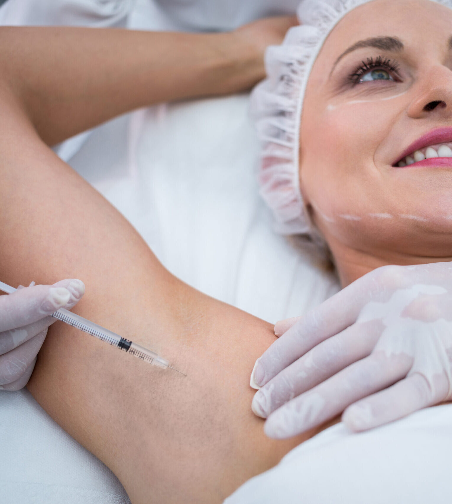 Close-up of doctor injecting woman on her arm pits